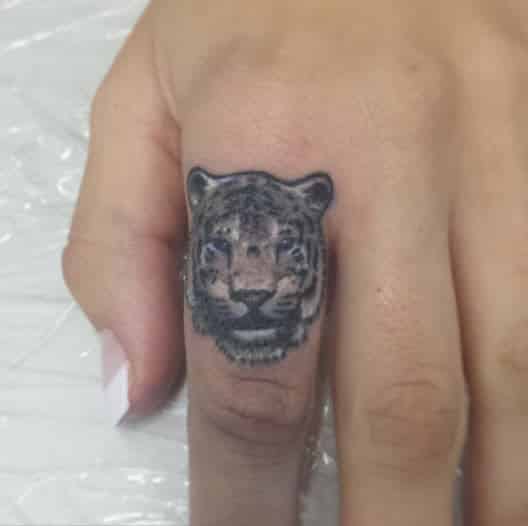 Tatuaje en el dedo indice con un tigre