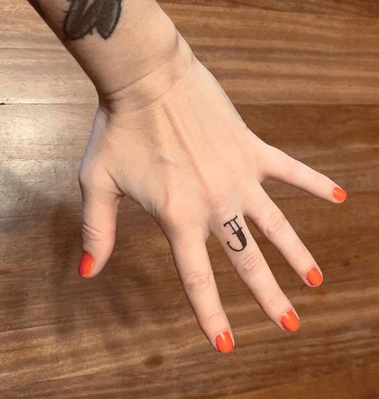 Tatuaje letra J en el dedo indice