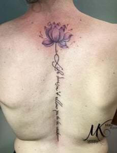 Estudios de tatuajes en Madrid - Tatuaje flor de loto y frase enla espalda