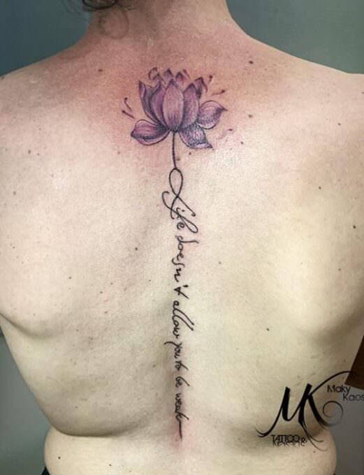 Tatuaje flor de loto y frase enla espalda