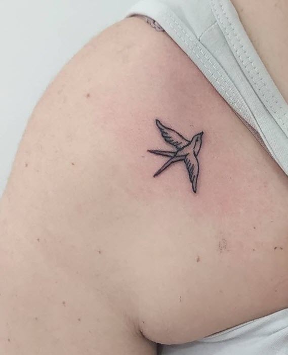 Tatuaje pequeño de una golondrina en el hombro