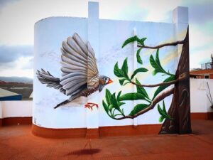 Graffiti comercial en Barcelona - Decoración de terraza privada con mural de 4 metros de altura con un pájaro y un árbol