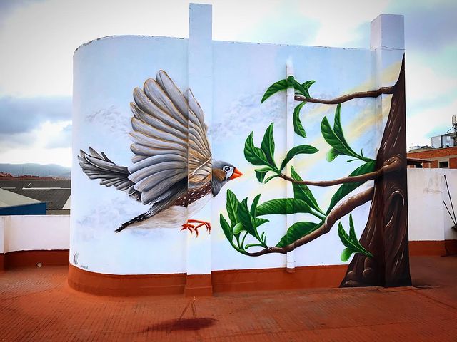 Decoración de terraza privada con mural de 4 metros de altura con un pájaro y un árbol