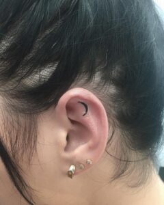 Tattoos en la oreja - Micro tatuaje de una media luna dentro de la oreja